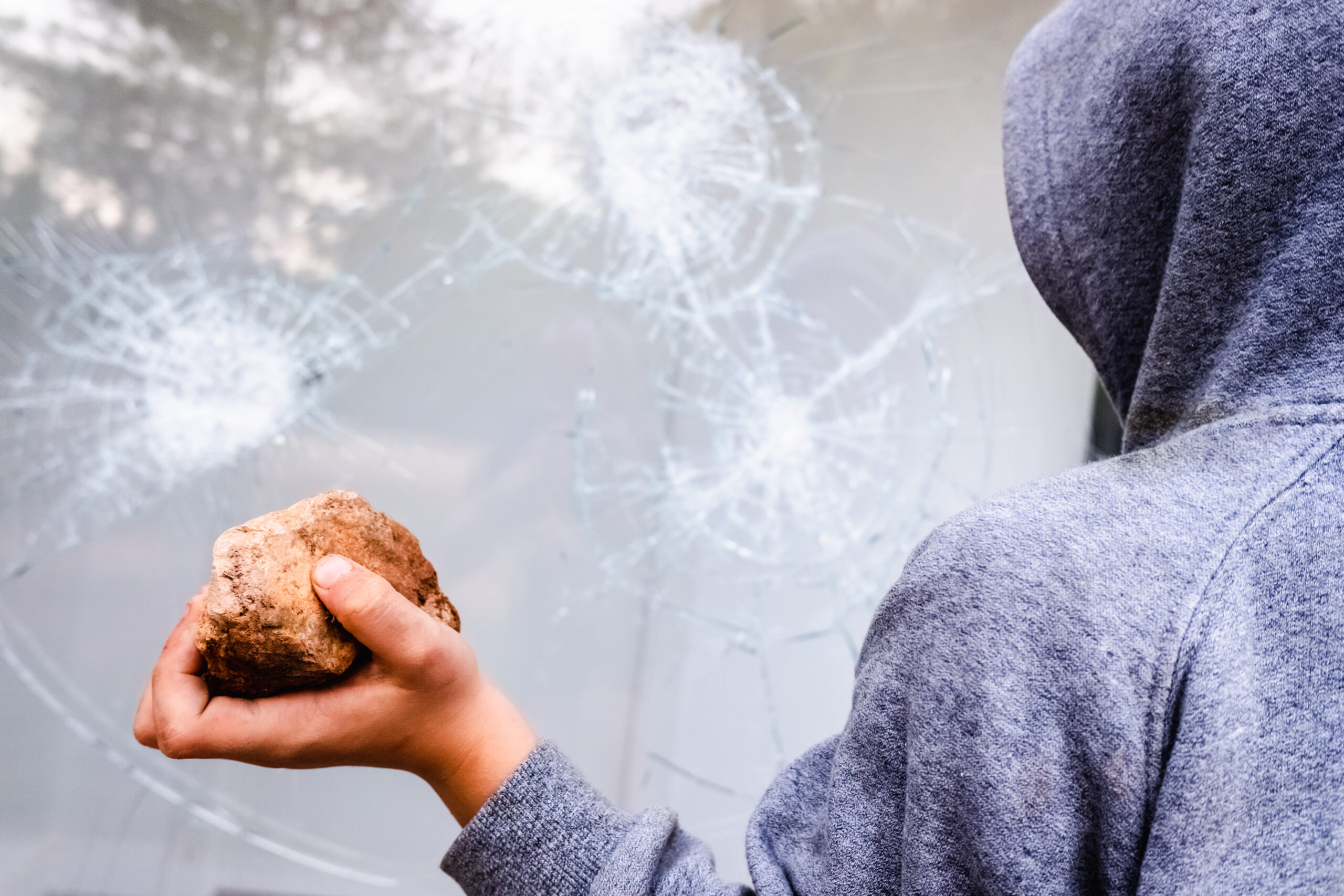 child holds a stone to throw it against a glass an 2024 10 18 23 40 45 scaled